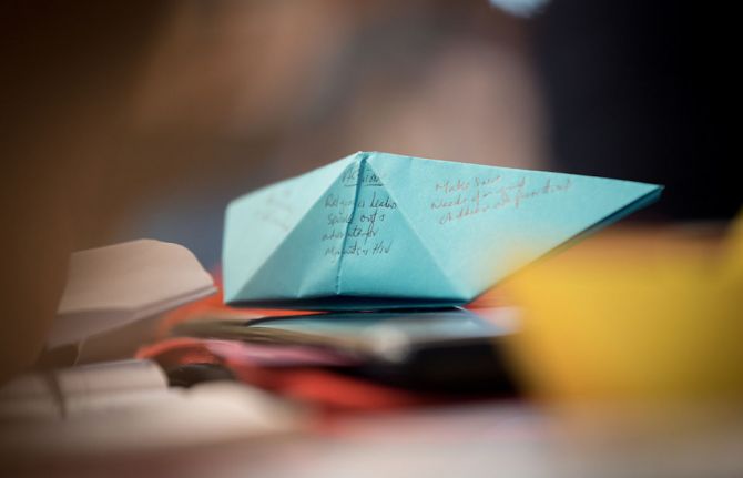 Photo: Albin Hillert/WCC. 20 February 2019, Geneva, Switzerland: Remembering the many people on the move, and the particular vulnerability of people migrating by boat, participants write down challenges and ways forward on symbolic boats during the worksh